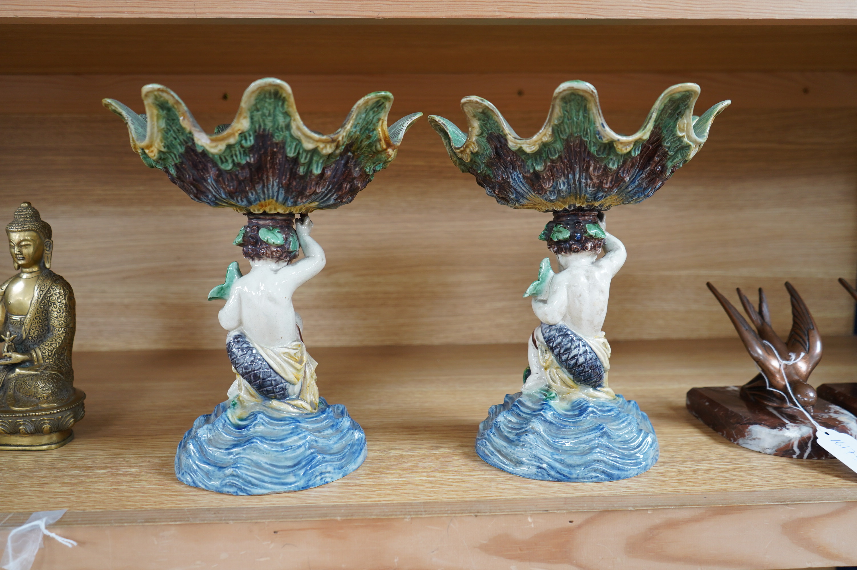 A pair of 19th century majolica comports with putti stems, 25cm. Condition - one repaired